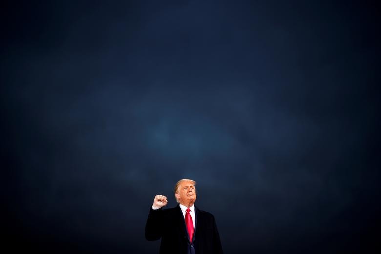 President Trump makes a fist during a campaign rally at Des Moines International Airport in Des Moines, Iowa. REUTERS/Carlos Barria  